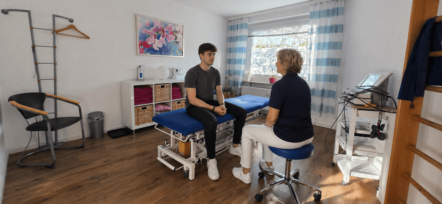 Beratungsgespräch zwischen Therapeutin und Patient im hellen Behandlungsraum – Physiotherapie Saglam, Langenhagen